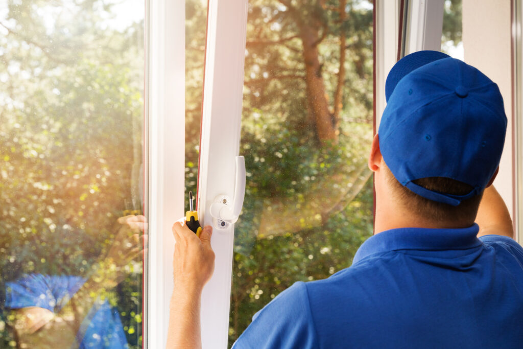 Greenwich window contractor in blue uniform installing new plastic pvc window
