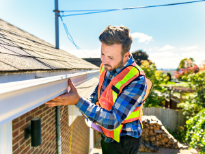 Expert roofer in Darien inspecting a roof, showcasing our company's GAF certification and expertise.