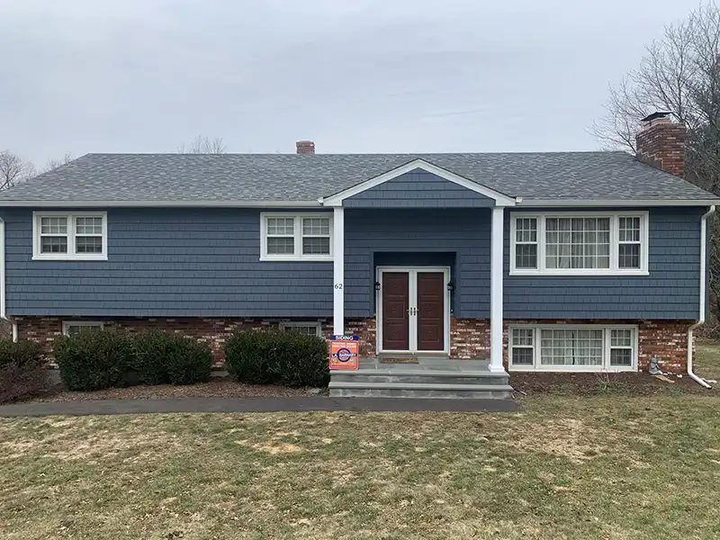 Small home with new blue siding installed by L. A. Barnaby & Sons
